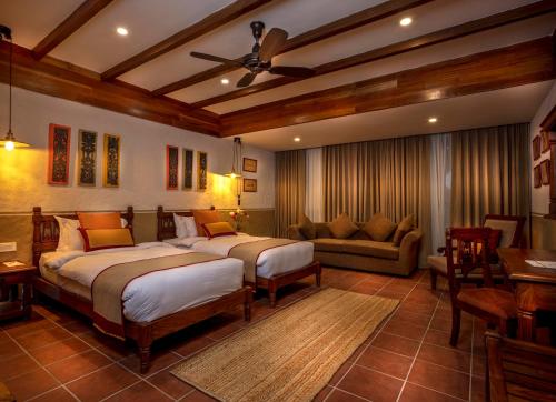 a bedroom with two beds and a couch at Nepali Ghar Hotel, Thamel - Your Home In Nepal in Kathmandu