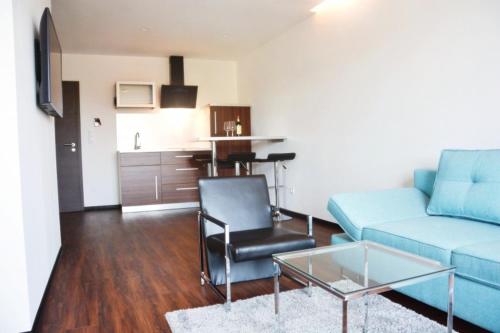 a living room with a blue couch and a table at X-Hotel in Emsdetten