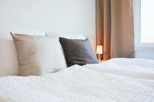 een bed met 2 kussens en een wit laken bij X-Hotel in Emsdetten