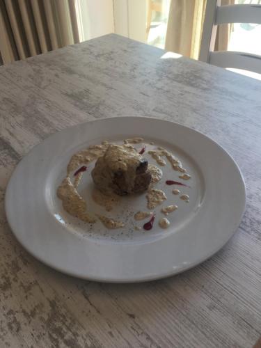 a white plate with a ball of food on a table at Albergo Ristorante Belcantone in Novaggio