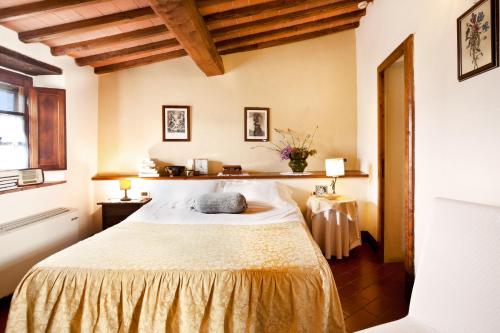 a bedroom with a bed in a room with wooden ceilings at Romitorio di Serelle in Barberino di Val dʼElsa