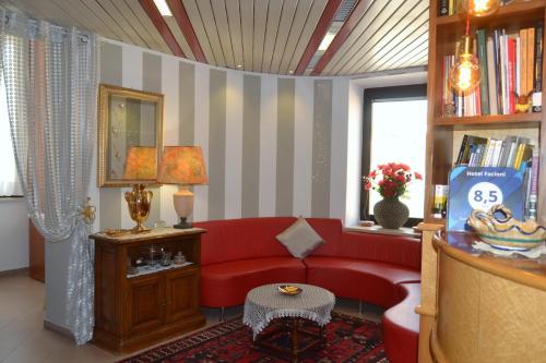 a living room with a red couch and a window at Hotel Facioni in Pomezia