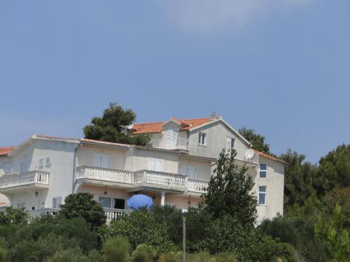 a large white building with trees in front of it at Radojka in Primošten