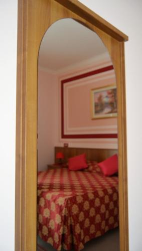 a mirror in a bedroom with a bed in it at Hotel Facioni in Pomezia