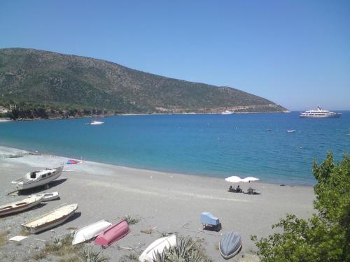 a beach with boats and umbrellas in the water at Hotel PARALIAKO Kyparissi in Kyparíssion