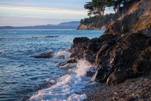 a rocky beach with waves crashing on the shore at 9 Condo in Lopez