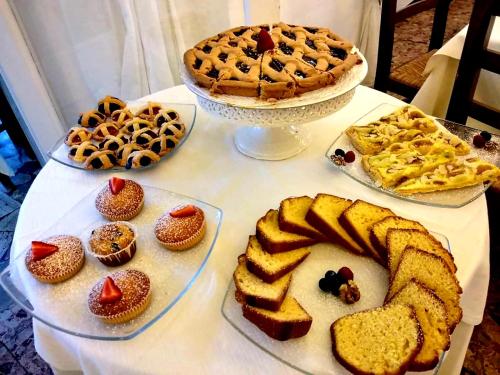 a table with several plates of food and a pie at Hotel La Primula in Forte dei Marmi