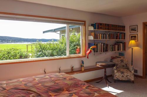 a bedroom with a window and a bed and a chair at 9 Condo in Lopez