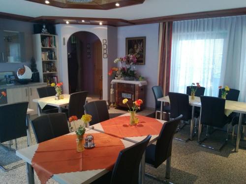 a dining room with tables and chairs and a kitchen at Ferienparadies Gutounik in Pörtschach am Wörthersee