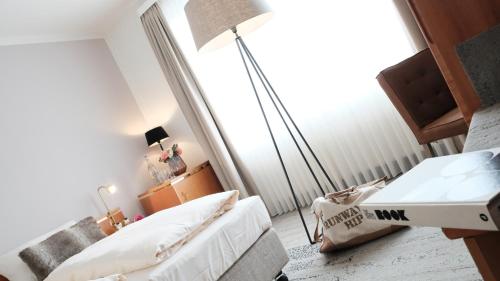 a bedroom with a bed and a desk and a lamp at Hotel Zur Post in Wiehl