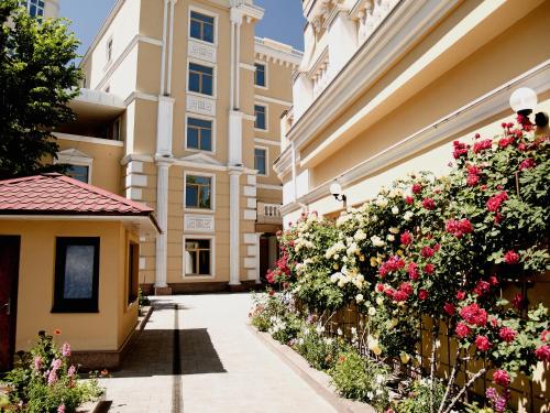 a courtyard of a building with flowers and a fence at GRAND OTRADA Hotel Resort & SPA in Odesa