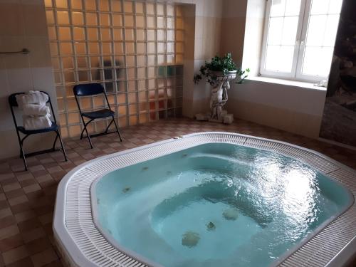 y baño con bañera grande y silla. en Sunvita, en Lądek-Zdrój