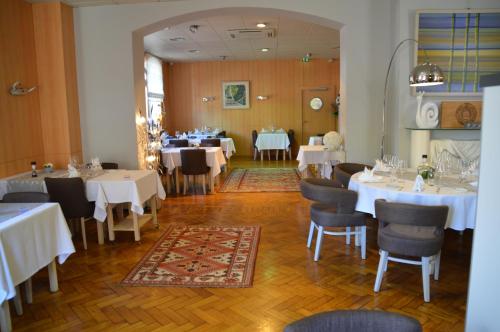 een eetkamer met witte tafels en stoelen bij Hostellerie d'Alsace in Cernay