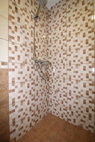 a bathroom with a shower with a tiled wall at Sauliaus apartamentai in Panevėžys