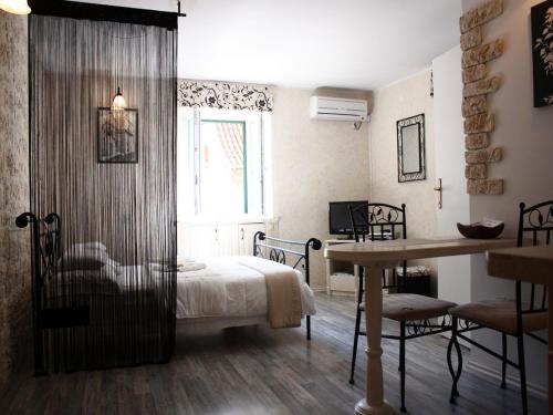 a bedroom with a bed and a table and a window at Old Town Apartment in Šibenik