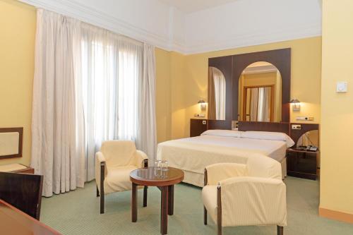 a hotel room with two beds and a table at Hotel Soho Boutique Jerez in Jerez de la Frontera