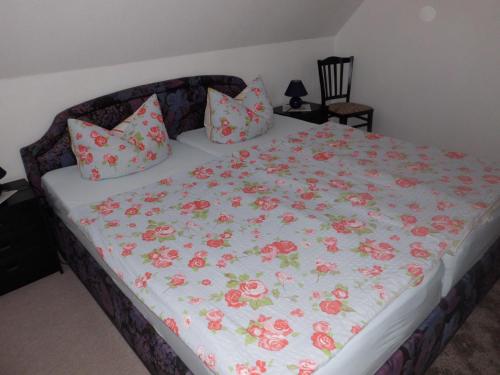 ブルクにあるFerienwohnung Carola Lehmannの花の毛布と枕が付いたベッド
