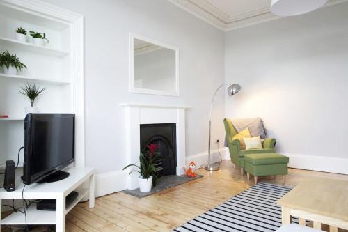 a living room with a tv and a fireplace at Stylish City Centre Apartments - D Terrace Residence in Edinburgh