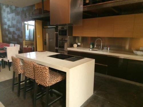 a kitchen with a counter and some chairs in it at Sliema La Loggia Suites in Sliema