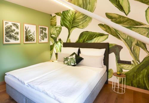 1 dormitorio con 1 cama con un mural de plantas en QUARTIER 82 by Arcadeon, en Hagen