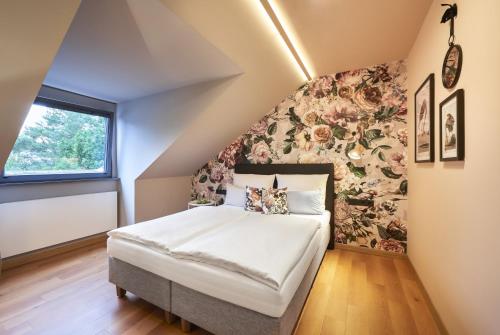 a bedroom with a bed with a floral wall at QUARTIER 82 by Arcadeon in Hagen