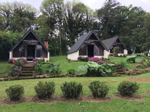 a house in a garden with flowers and plants at Villa Calas in Vara Blanca