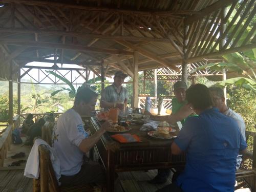 a group of people sitting around a table eating food at De Salak Homestay in Bogor