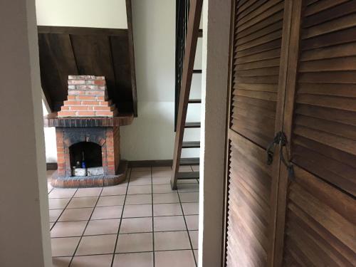 a room with a brick fireplace next to a door at Villa Calas in Vara Blanca