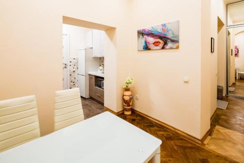 リヴィウにあるLEOGRAND Apartments on Stavropigiyska 7のキッチン、ダイニングルーム(白いテーブル、椅子付)