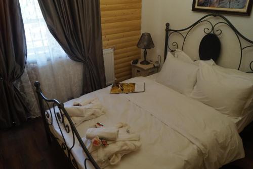 a bedroom with a white bed with towels on it at Вила Поликсения Петиня in Tryavna
