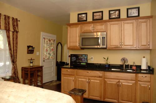 a kitchen with wooden cabinets and a microwave at Charming Historic Downtown Apartment in Saint Augustine