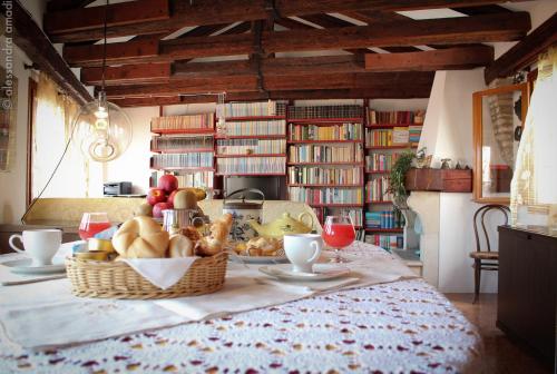 uma mesa com um cesto de pão e fruta em Altana Rialto Apartment em Veneza