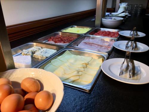 a buffet with several trays of food on a table at Hotel Xalet Verdú in Arinsal
