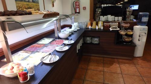 a buffet line in a restaurant with food and desserts at Hotel Xalet Verdú in Arinsal