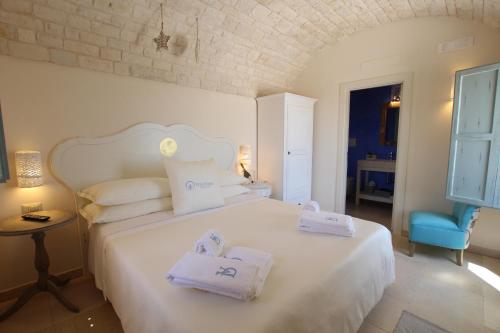アルベロベッロにあるVita Dorata - rural chicのベッドルーム1室(白いベッド1台、タオル付)