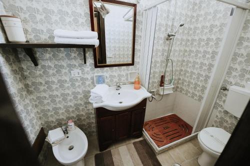 bagno con lavandino, servizi igienici e specchio di monolocale "le sciabiche" a Brindisi