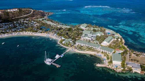 an island in the ocean with a boat in the water at St. James's Club Resort - All Inclusive in English Harbour Town