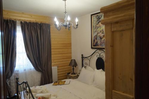 a bedroom with a bed and a chandelier at Вила Поликсения Петиня in Tryavna