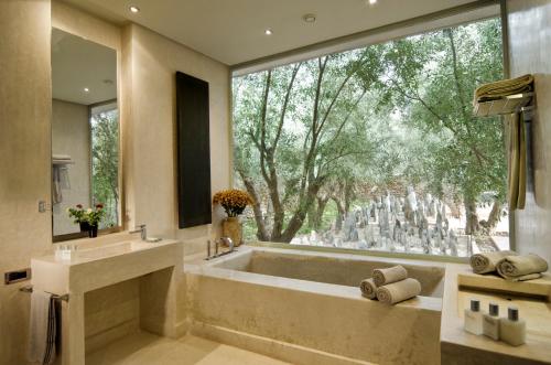 uma grande casa de banho com banheira e uma grande janela em Dar Sabra em Marrakech