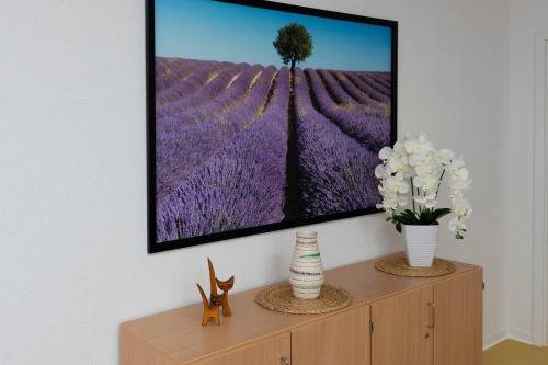 a tv on a wall with a picture of a lavender field at Sonnenschein Appartement in Ober-Hambach