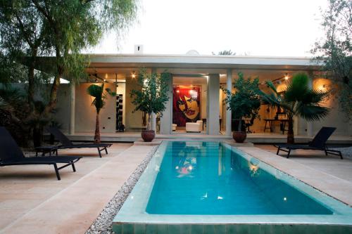 a swimming pool in front of a house at Dar Sabra in Marrakech