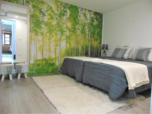a bedroom with a bed with a mural of trees at Casa da Fonte in Tarouca