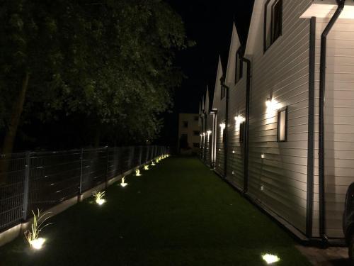 a row of lights on the side of a building at night at Tu Urlop in Mielno