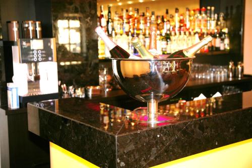 a bar with a bucket of wine bottles on a counter at Hotel Favor in Düsseldorf