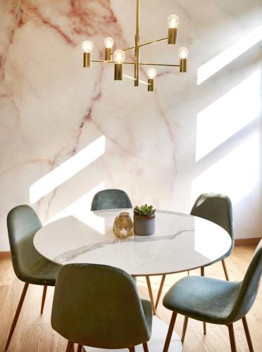 a dining room with a white table and green chairs at QUARTIER 82 by Arcadeon in Hagen