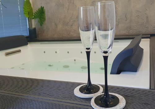 two champagne glasses sitting on a table next to a bath tub at Residence Villa Rosa dei Venti in Cinisi