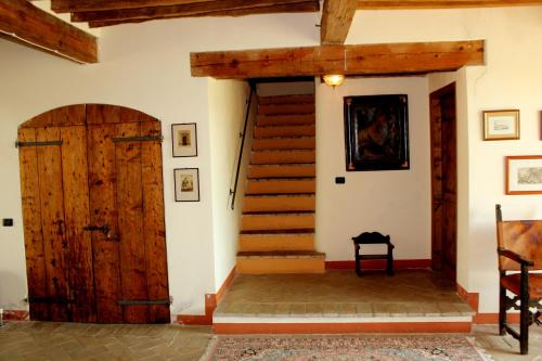 een ingang naar een huis met een houten deur en trap bij B&B Il Conte Giacomo in Viarolo