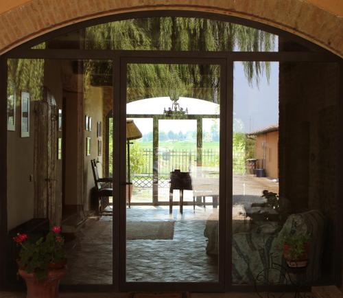 eine offene Tür zu einer Terrasse mit einem Tisch in der Unterkunft B&B Il Conte Giacomo in Viarolo