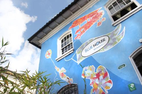 a blue building with flowers painted on it at Blue House Youth Hostel in Quito