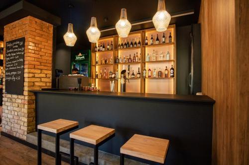 a bar with two stools in front of a counter at Hotel Tomas in Šiauliai